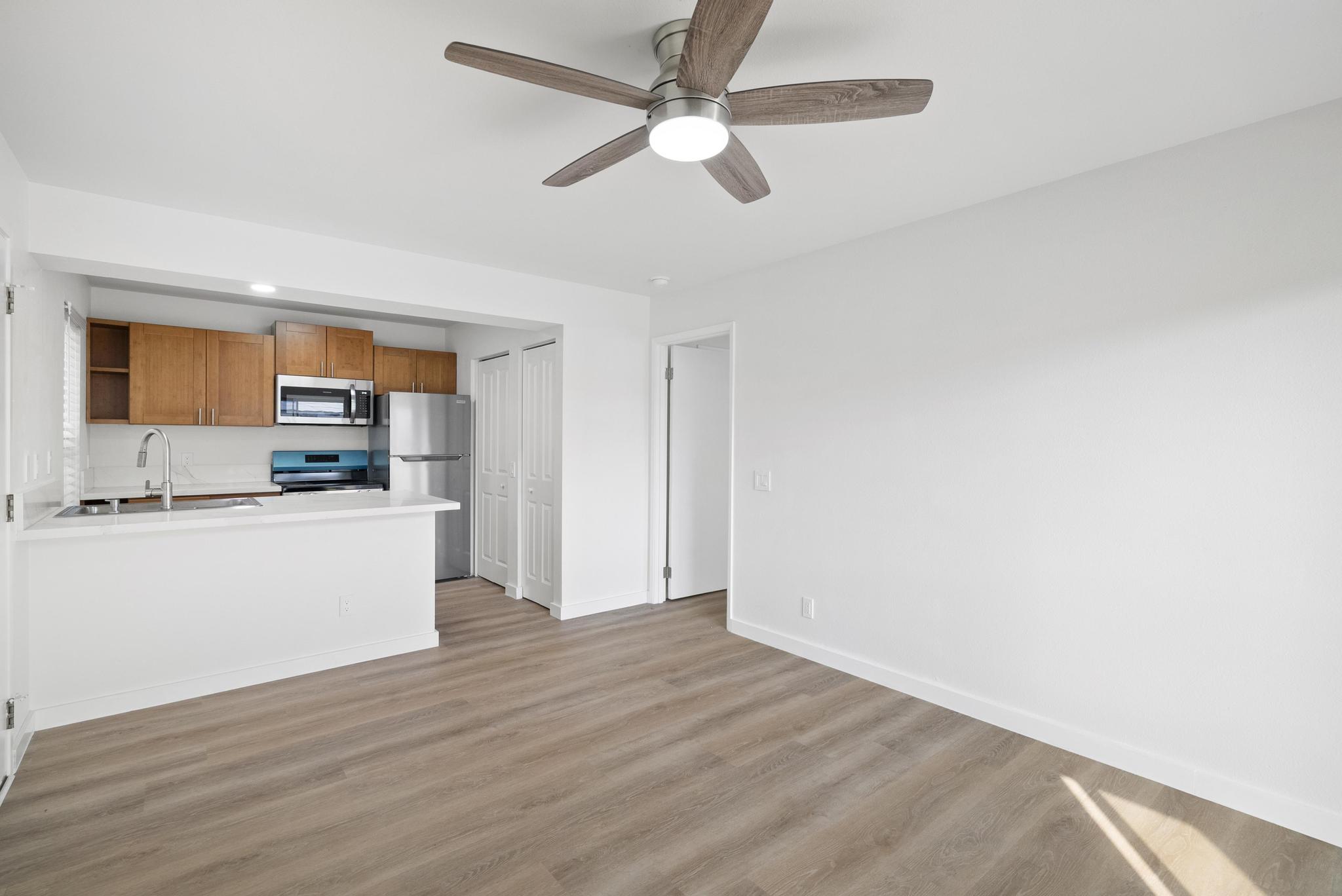 68-3831 Lua Kula Street, Unit E102 Waikoloa, HI 96738 - Photo 4 of 26 a view of a kitchen with a sink and dishwasher a kitchen island with wooden floor