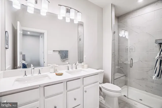 a bathroom with a double vanity sink toilet and shower