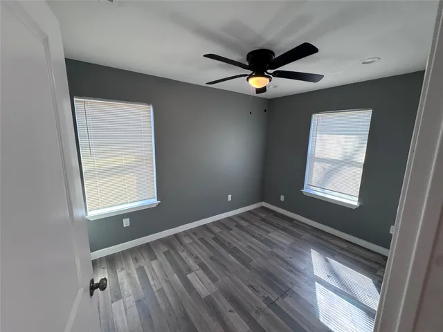 a view of an empty room and window and wooden floor