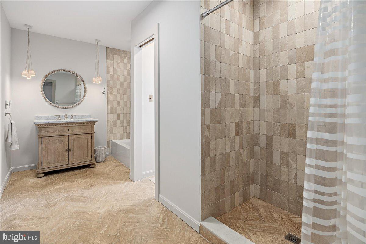 3903 Belle Rive Terrace Alexandria, VA 22309 - Photo 30 of 69 a bathroom with a sink a mirror and a shower