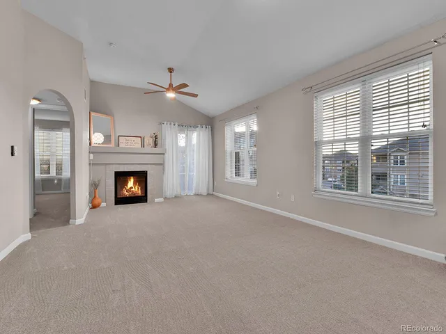 a view of empty room with a fireplace and windows