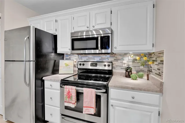 a kitchen with stainless steel appliances granite countertop a stove a refrigerator and a microwave