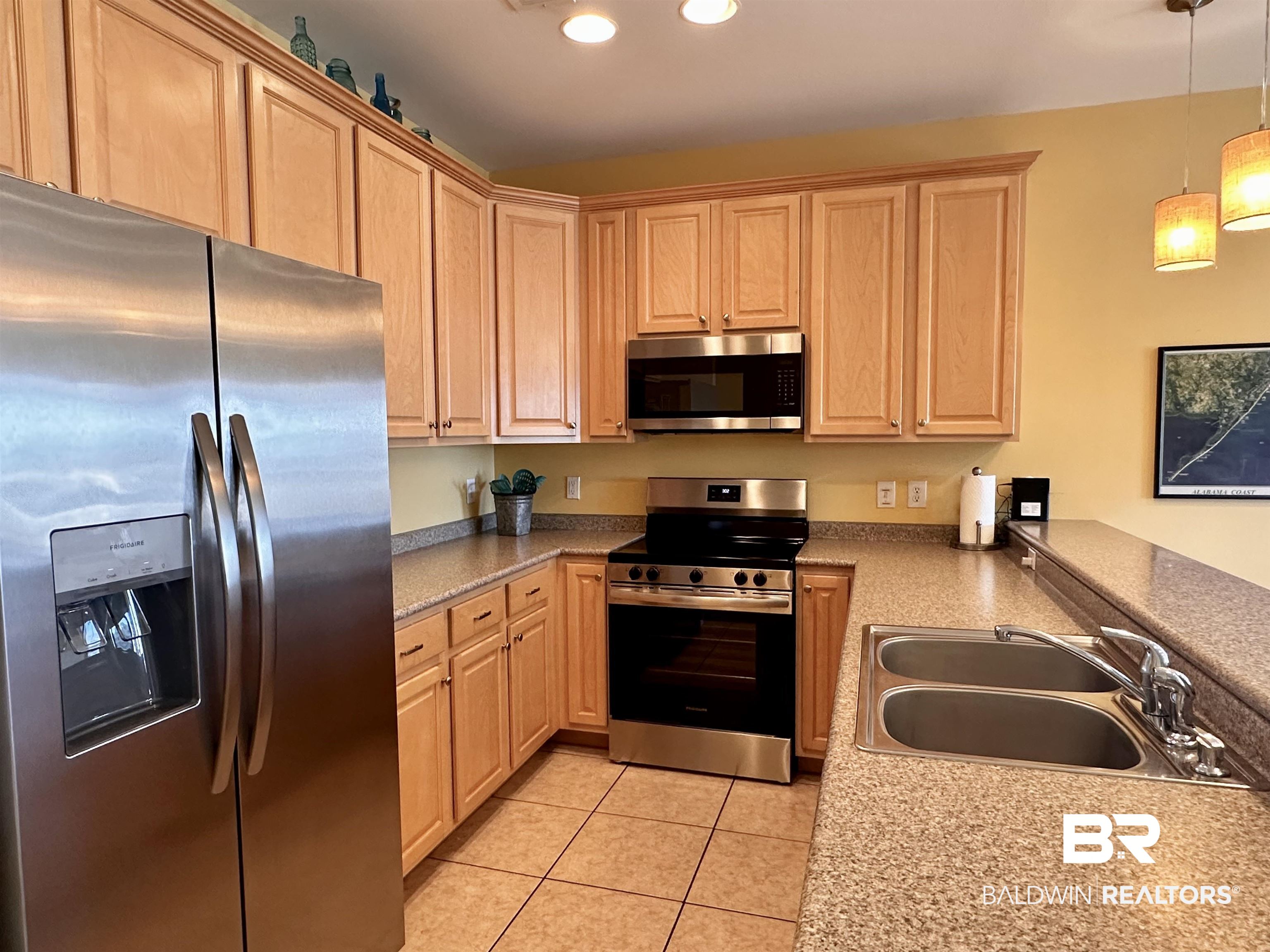 1472 Sandy Lane, Unit A Gulf Shores, AL 36542 - Photo 28 of 44 Kitchen featuring appliances with stainless steel finishes, sink, pendant lighting, and light brown cabinetry