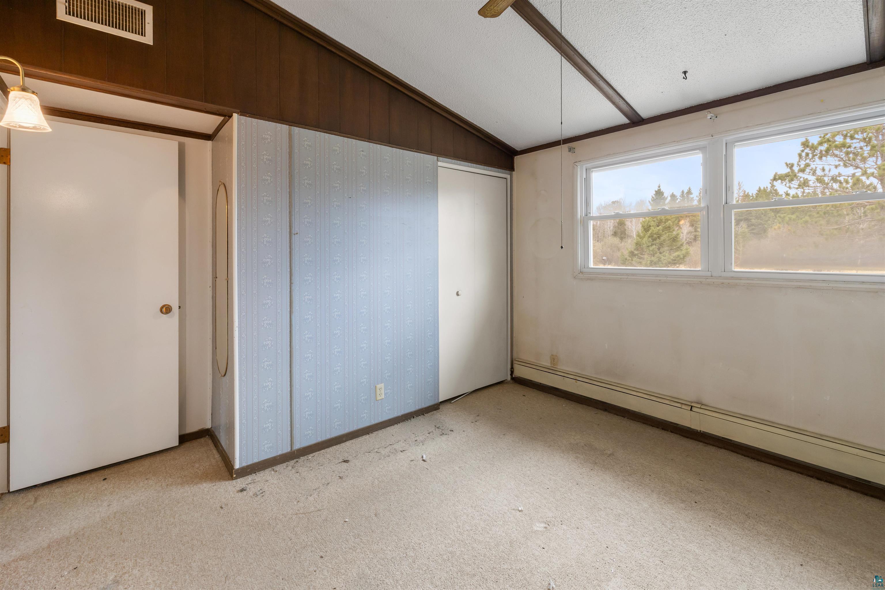 11574 Town Line Road Hibbing, MN 55746 - Photo 12 of 41 Room featuring dual windows, vaulted ceiling with wood-finish beams, and carpet flooring