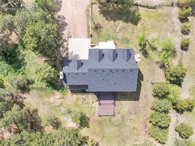 an aerial view of a house with a yard and large trees