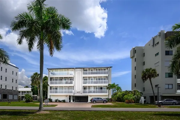 a front view of a building with palm trees