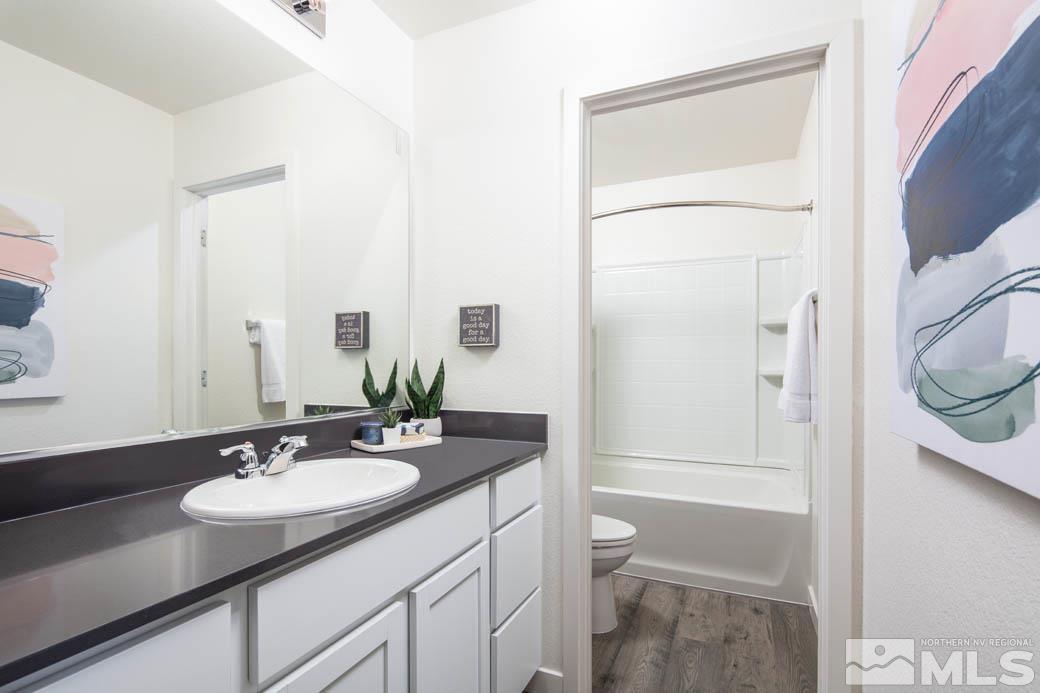 7789 Wandering Way, Unit LOT #243 Reno, NV 89506 - Photo 13 of 15 a bathroom with a granite countertop sink toilet and shower