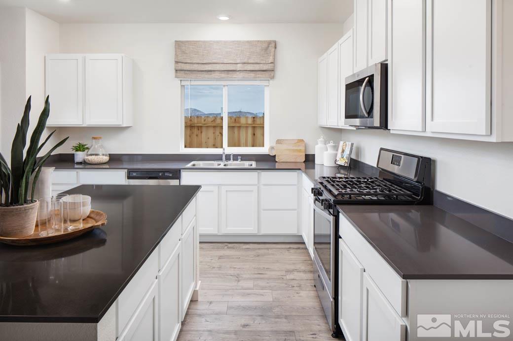 7789 Wandering Way, Unit LOT #243 Reno, NV 89506 - Photo 6 of 15 a kitchen with stainless steel appliances granite countertop a sink stove and cabinets