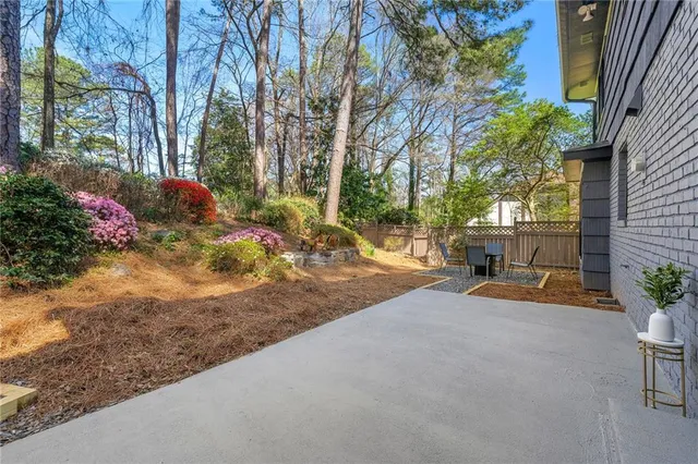 a view of backyard with table and chairs and potted plants