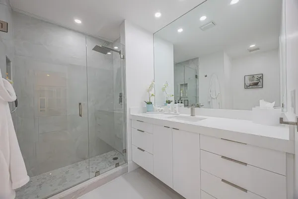 a bathroom with a shower sink and mirror
