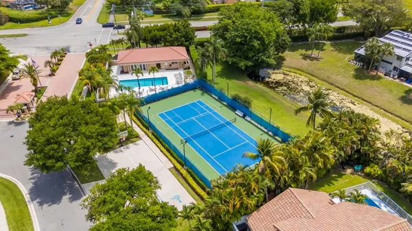 an aerial view of a tennis ground and a swimming pool