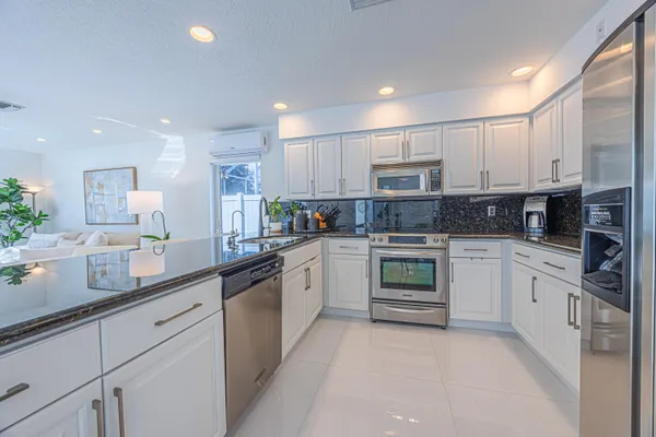 a kitchen with stainless steel appliances granite countertop a stove sink and cabinets