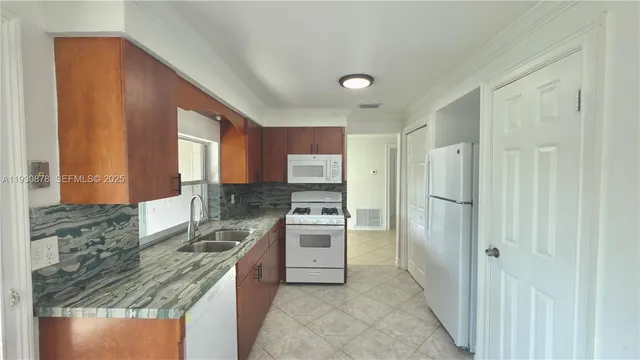 a kitchen with stainless steel appliances granite countertop a stove a sink and a refrigerator