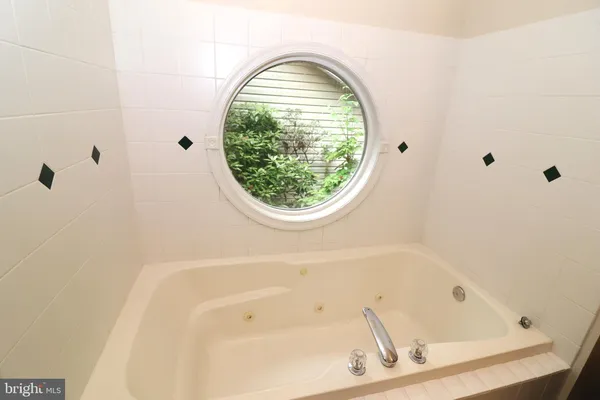 a bathroom with a toilet a sink a mirror and a window