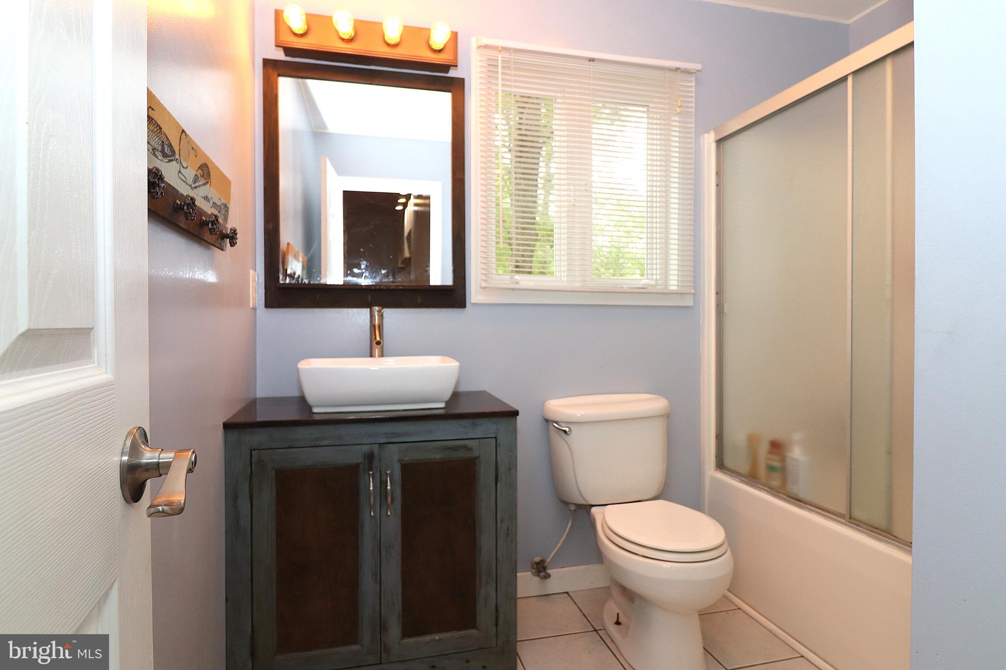 1111 Eastover Parkway Locust Grove, VA 22508 - Photo 28 of 62 a bathroom with a toilet a sink a mirror and a window