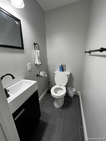 1029 Beekman Road, Unit 4 Hopewell Junction, NY 12533 - Photo 5 of 9 a bathroom with a toilet a sink and mirror