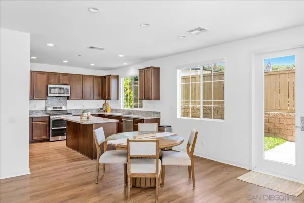 a kitchen with granite countertop a stove sink and microwave with wooden floor