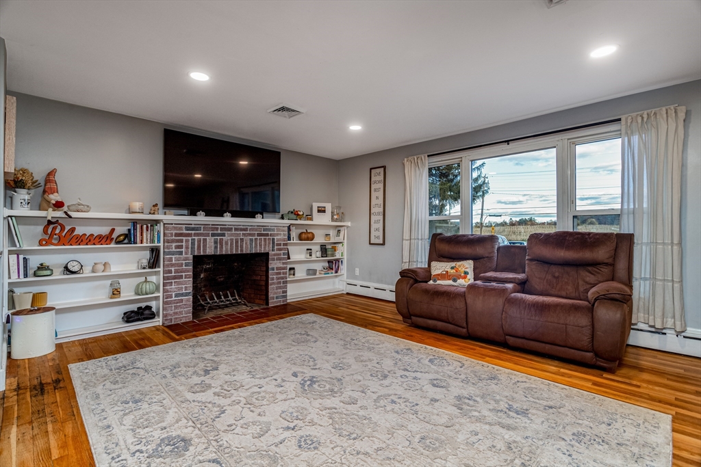 319 Chase Road Lunenburg, MA 01462 - Photo 7 of 26 a living room with furniture a fireplace and a flat screen tv