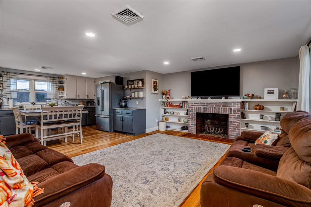 319 Chase Road Lunenburg, MA 01462 - Photo 8 of 26 a living room with furniture a fireplace and a flat screen tv