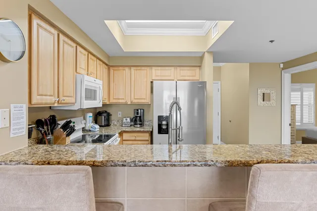 a kitchen with granite countertop a sink a refrigerator and a granite counter tops