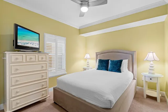 a bedroom with a bed and a flat tv screen on dresser