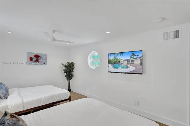 a bedroom with a bed and a flat tv screen on dresser