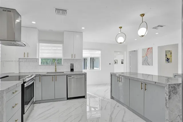 a kitchen with stainless steel appliances a table chairs and a chandelier