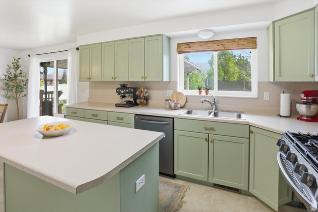 5108 South 2000th Street West Roy, UT 84067 - Photo 20 of 61 Kitchen featuring green cabinetry, stainless steel appliances, light countertops, and a kitchen island