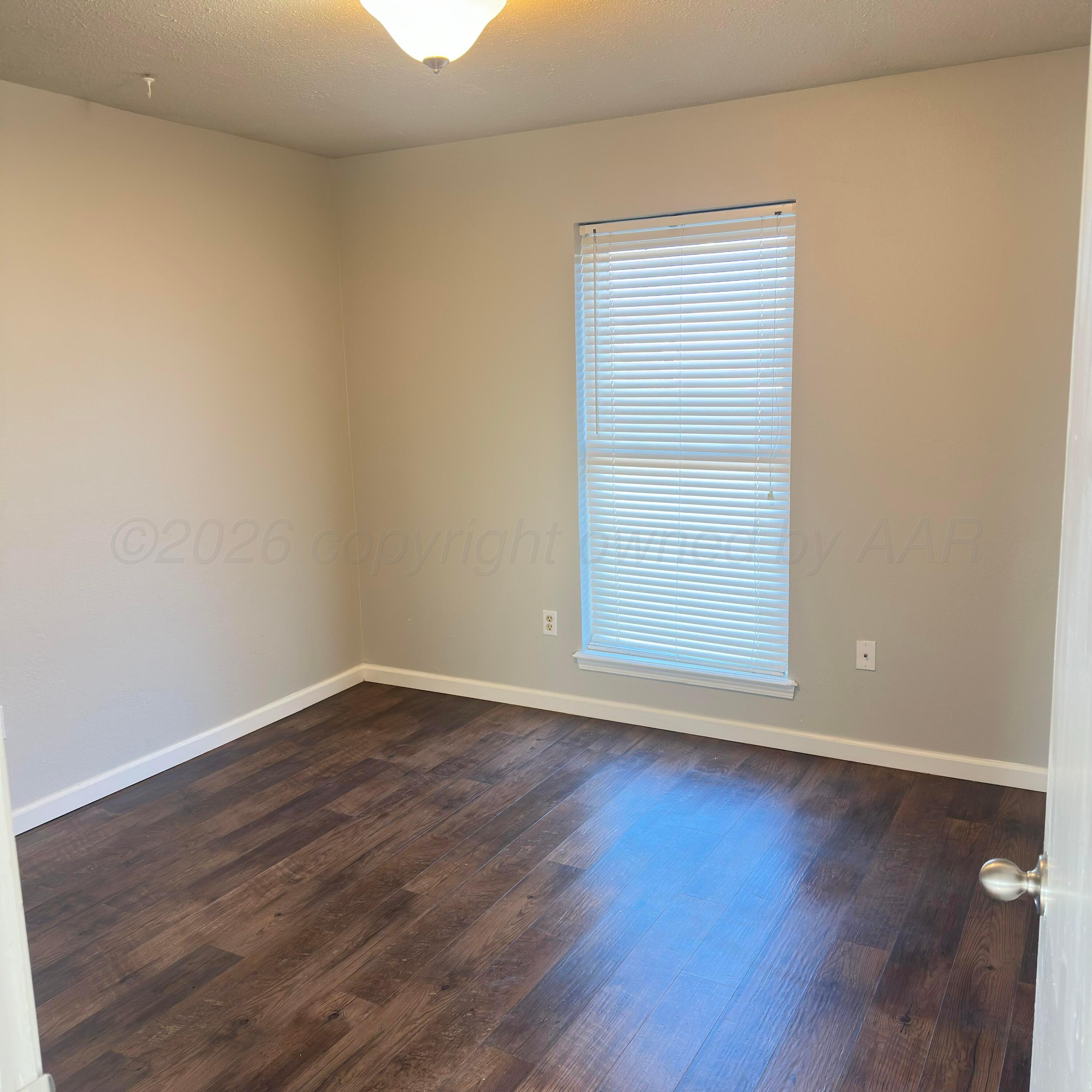805 Oregon Trail Canyon, TX 79015 - Photo 11 of 14 a view of an empty room with wooden floor and a window