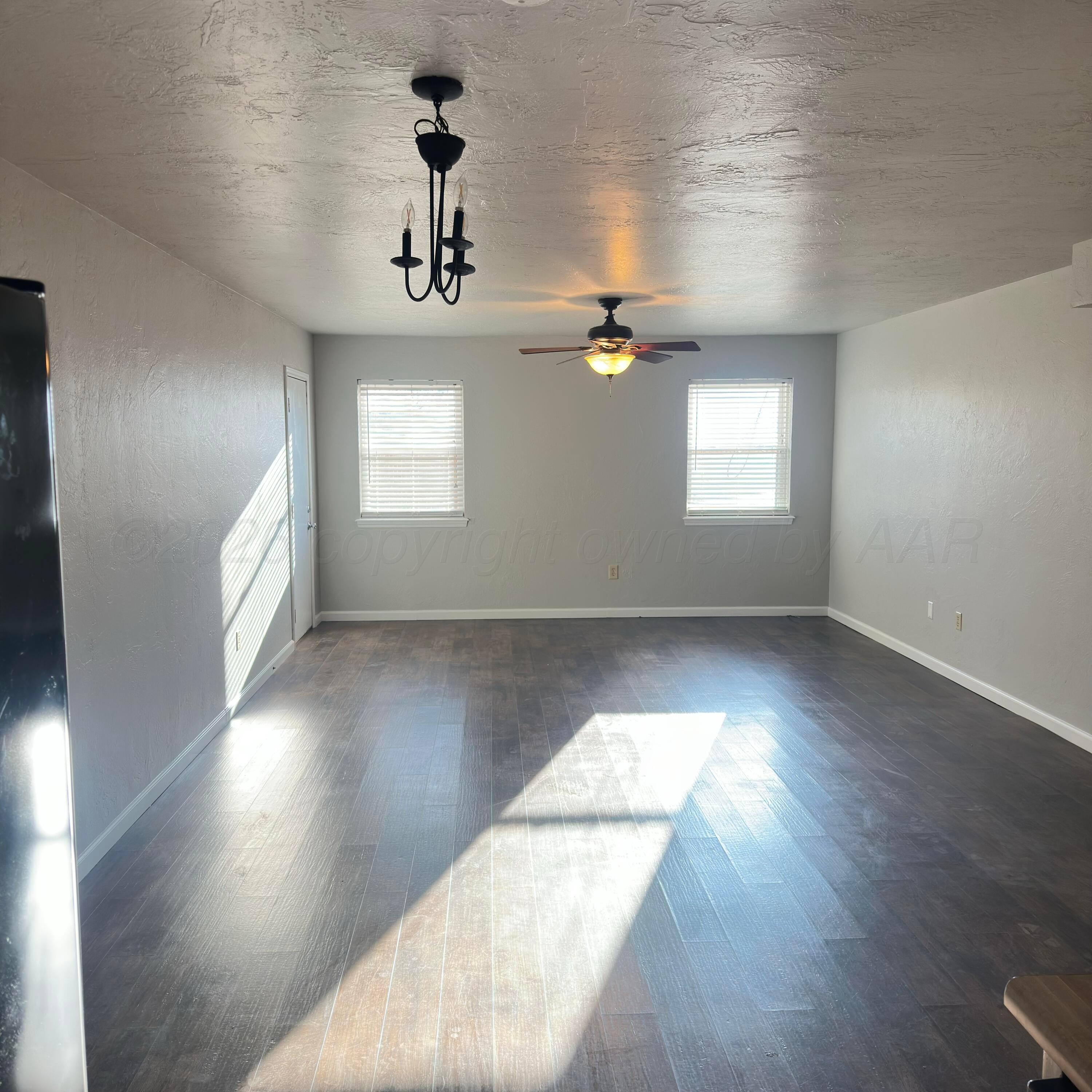 805 Oregon Trail Canyon, TX 79015 - Photo 3 of 14 an empty room with wooden floor chandelier and windows