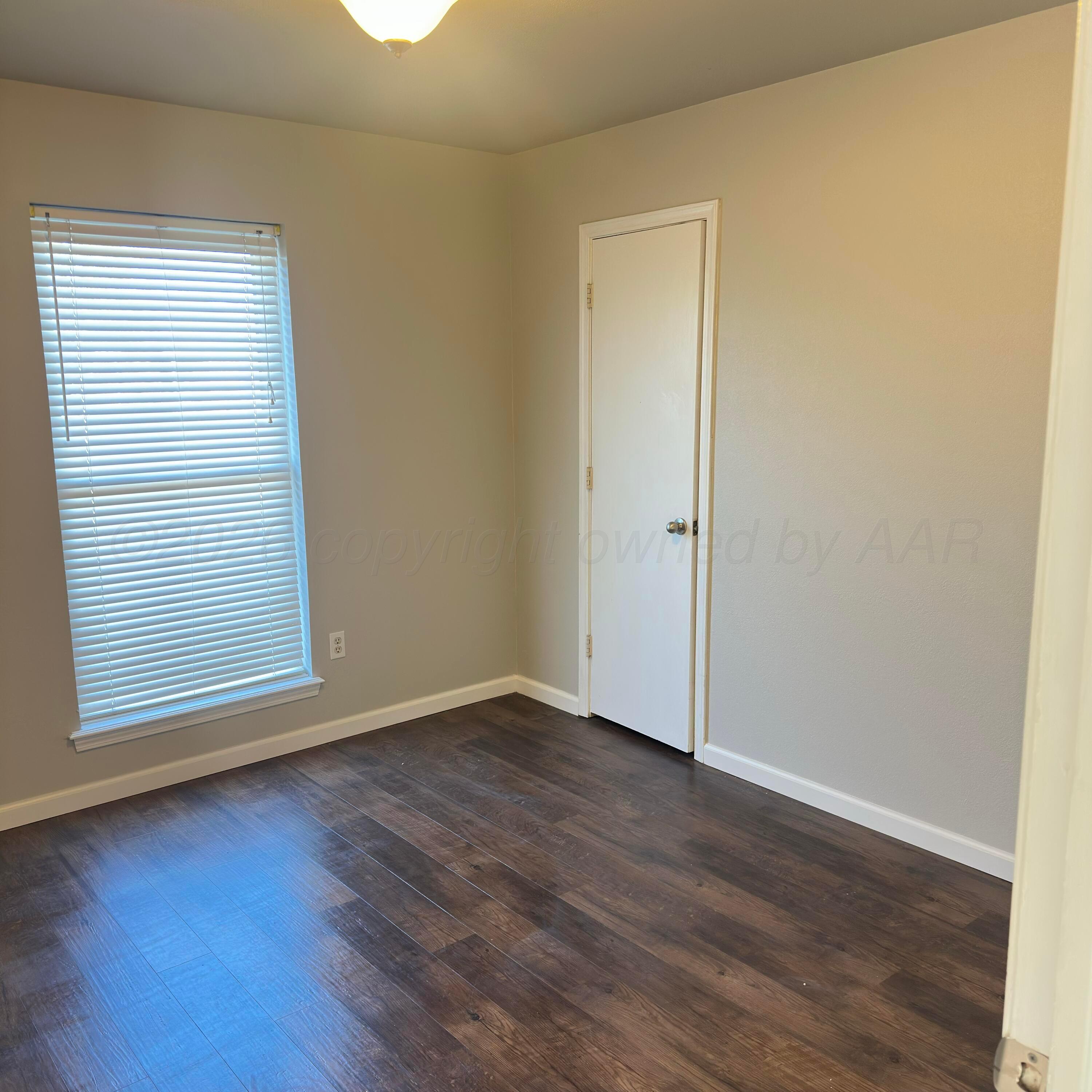 805 Oregon Trail Canyon, TX 79015 - Photo 10 of 14 an empty room with wooden floor and windows