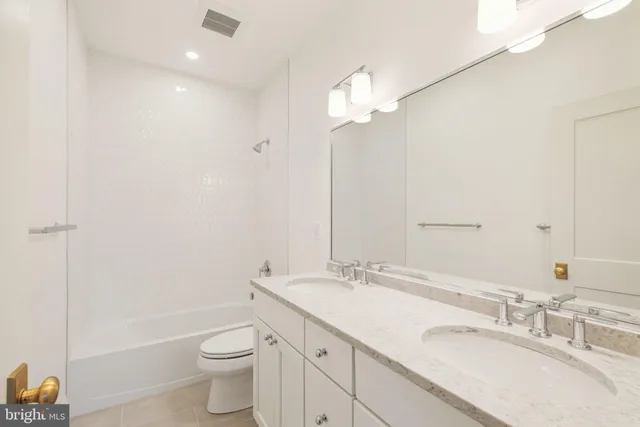 a bathroom with a granite countertop sink a toilet and bathtub