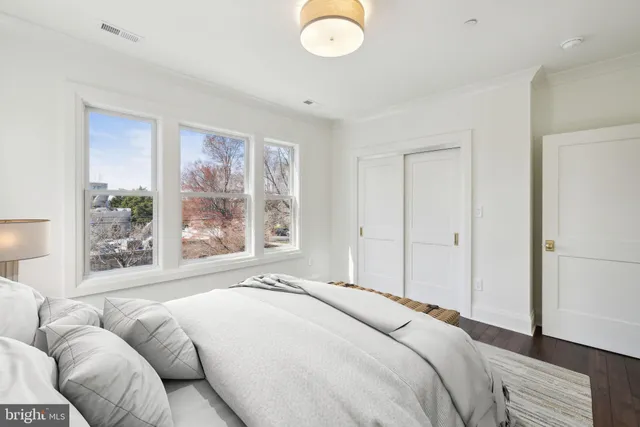 a bedroom with a bed and a large window