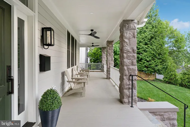 a view of a porch with chairs and potted plants