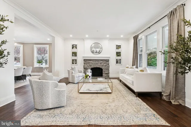 a living room with furniture a large window and a fireplace
