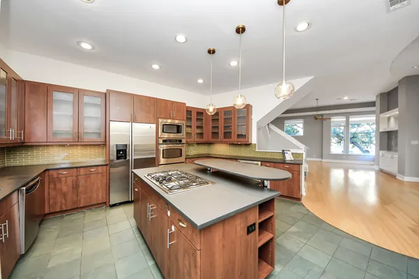 a kitchen with stainless steel appliances granite countertop a stove a refrigerator a sink and a counter