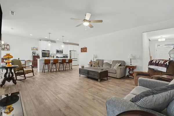 a living room with furniture and kitchen view