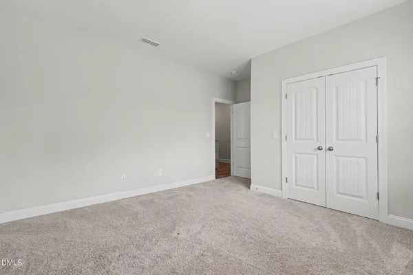 a view of an empty room and closet area