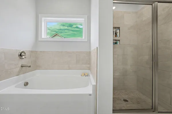 a white bath tub sitting next to a shower