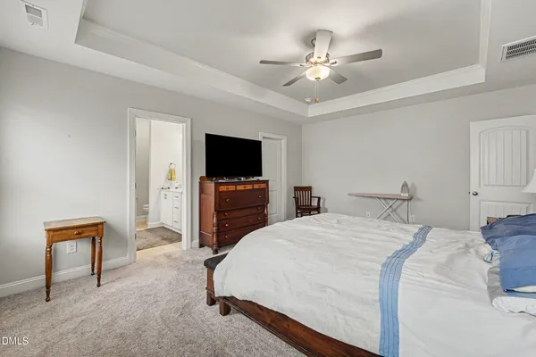 a spacious bedroom with a bed and a flat screen tv