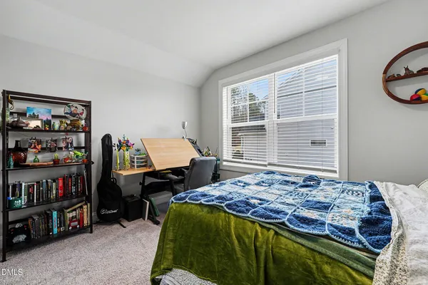 a bed sitting in a bedroom next to a window