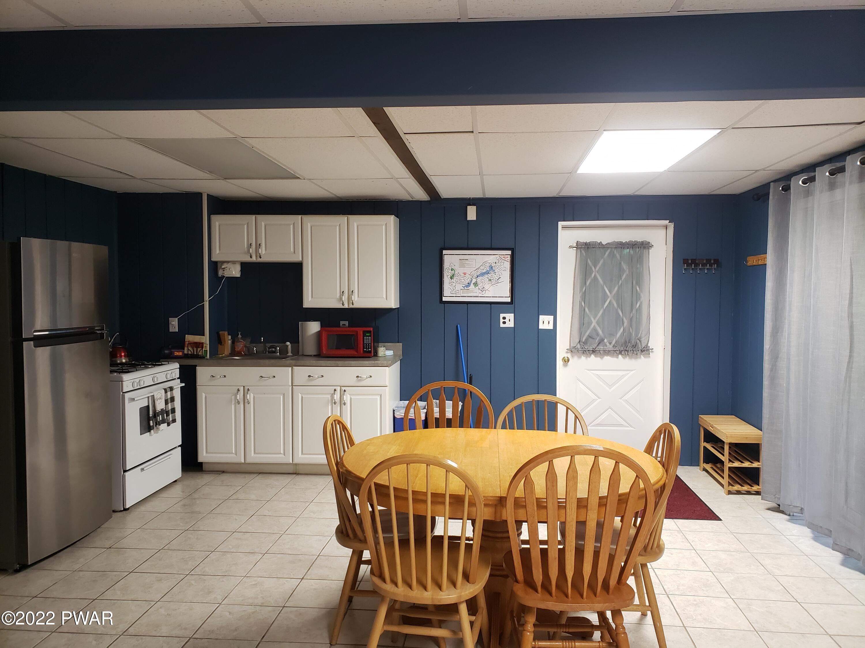 40 Crest View Road Lake Ariel, PA 18436 - Photo 9 of 32 a kitchen with a table chairs refrigerator a sink dishwasher and microwave with wooden floor