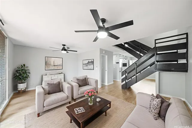 a living room with furniture and a ceiling fan