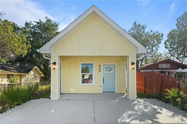 a view of a house with backyard and trees