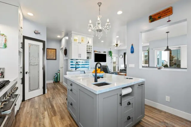a kitchen that has a lot of white furniture a refrigerator and a stove top oven
