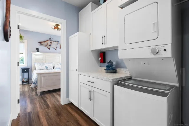 a kitchen with white cabinets and wooden floor