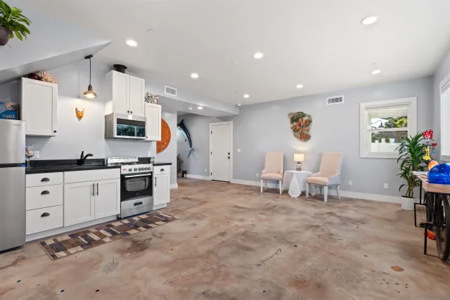 a large white kitchen with white cabinets and stainless steel appliances