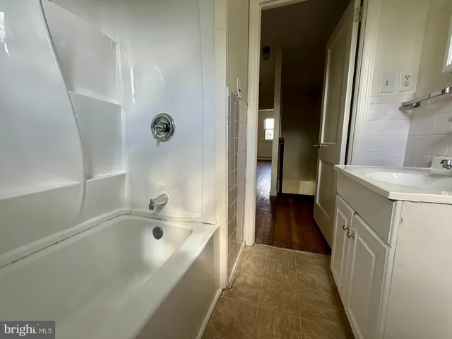 a bathroom with a bathtub sink and mirror
