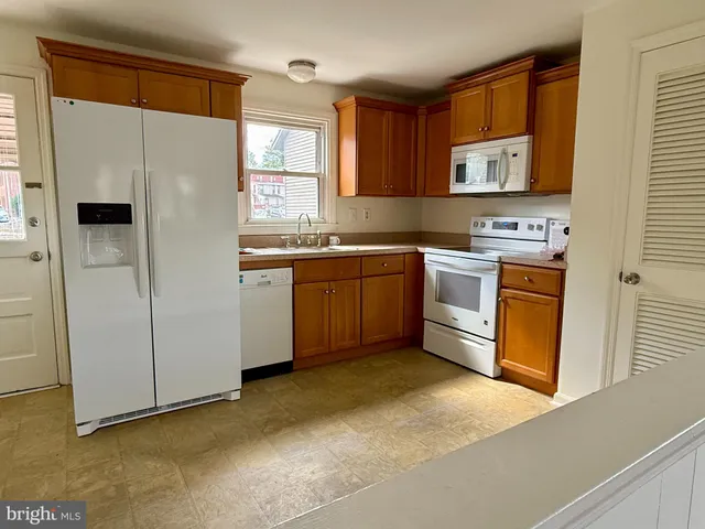 a kitchen with stainless steel appliances granite countertop a stove a sink dishwasher a refrigerator and a microwave oven