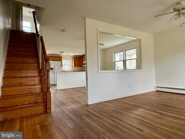 a view of a hallway with wooden floor and staircase